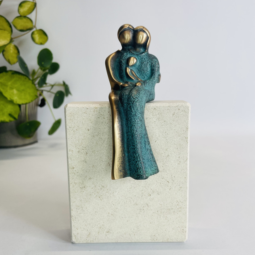 Siddende familie - bronzeskulptur på sten