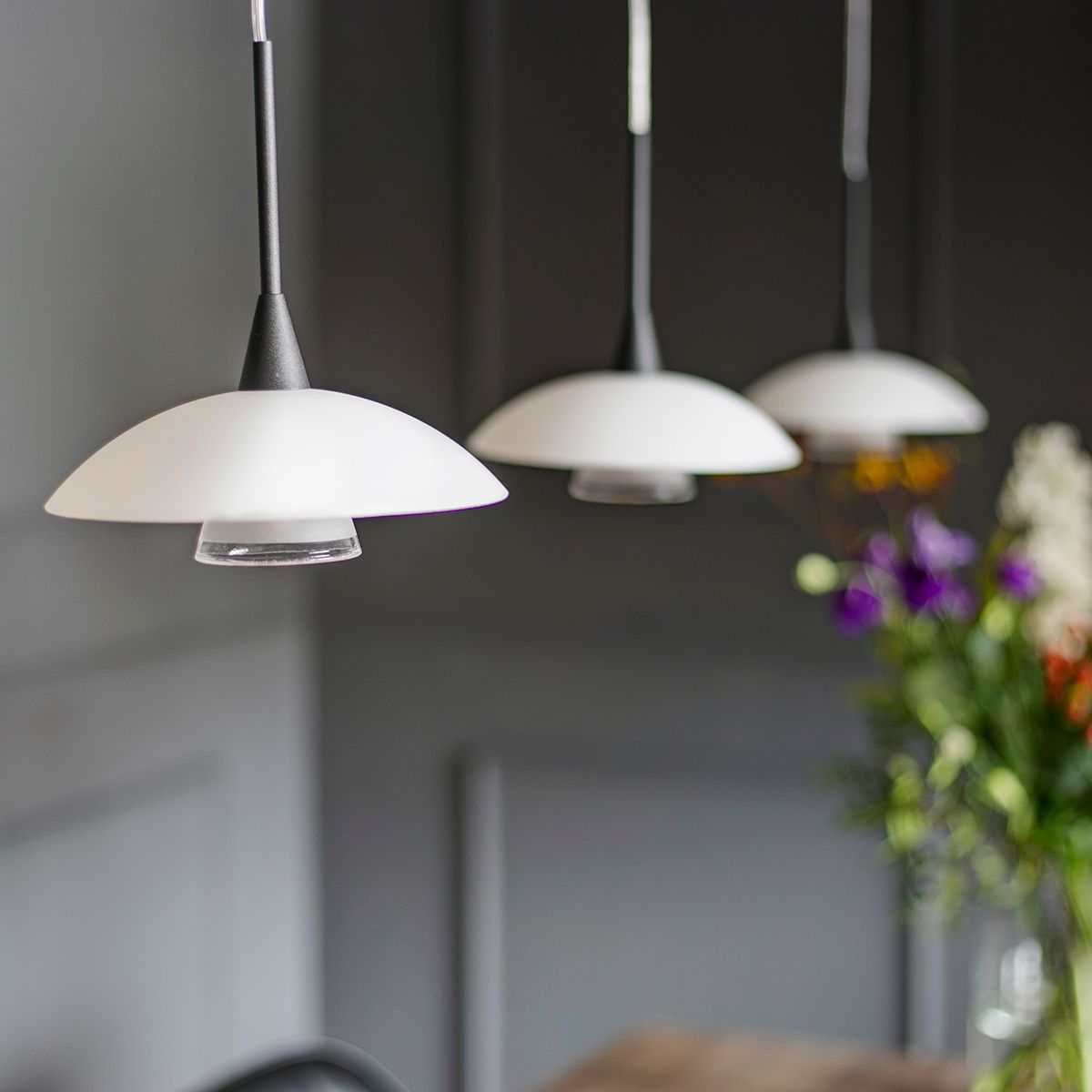 Plate - loftlampe i sort metal sammen med en glasskærm